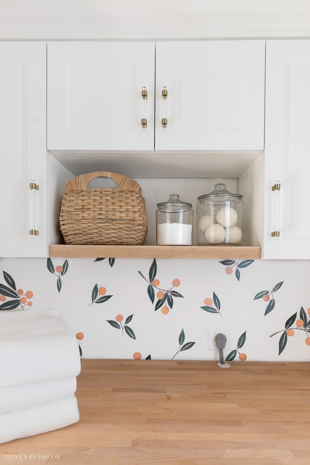 I added a wood shelf between the Ikea cabinets in our laundry room for open storage!