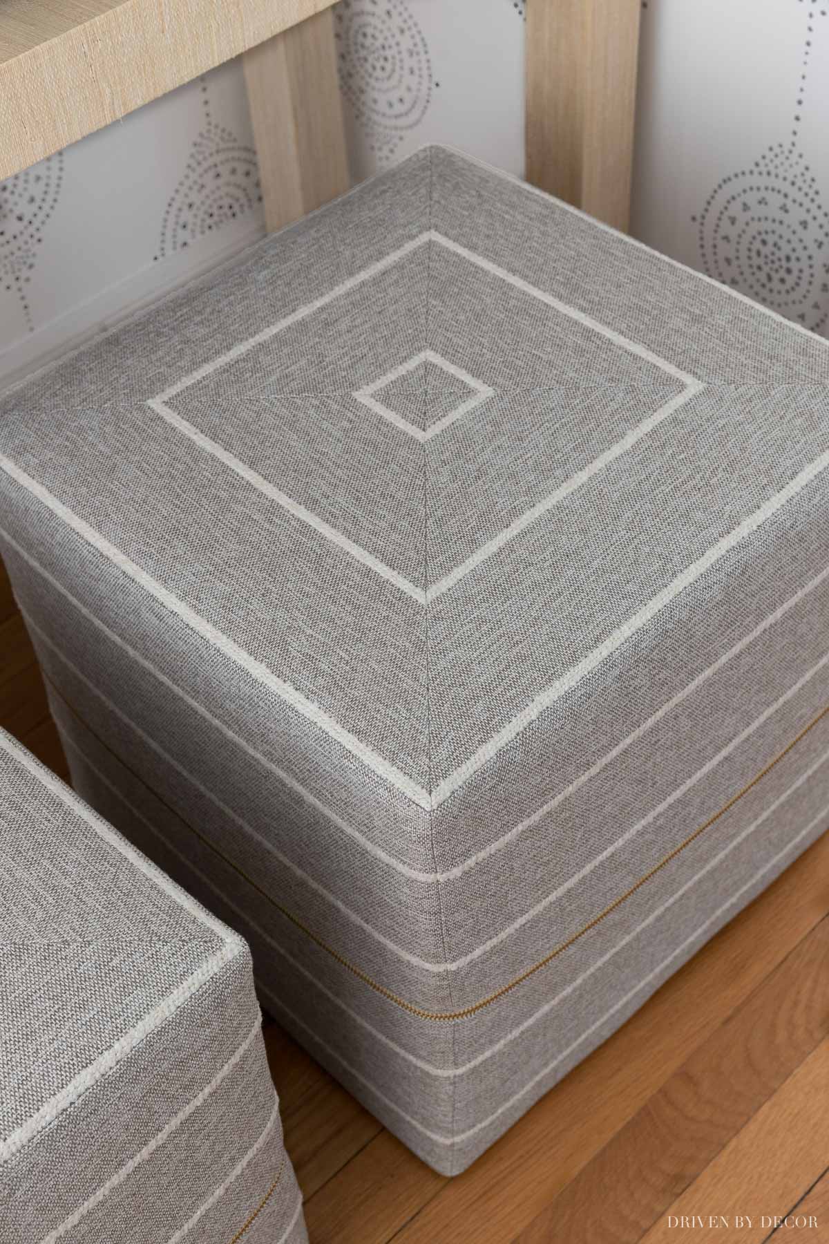 The gorgeous pair of gray and white ottomans under our entryway console table