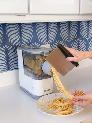 Cutting off the pasta as it comes out of the pasta making machine