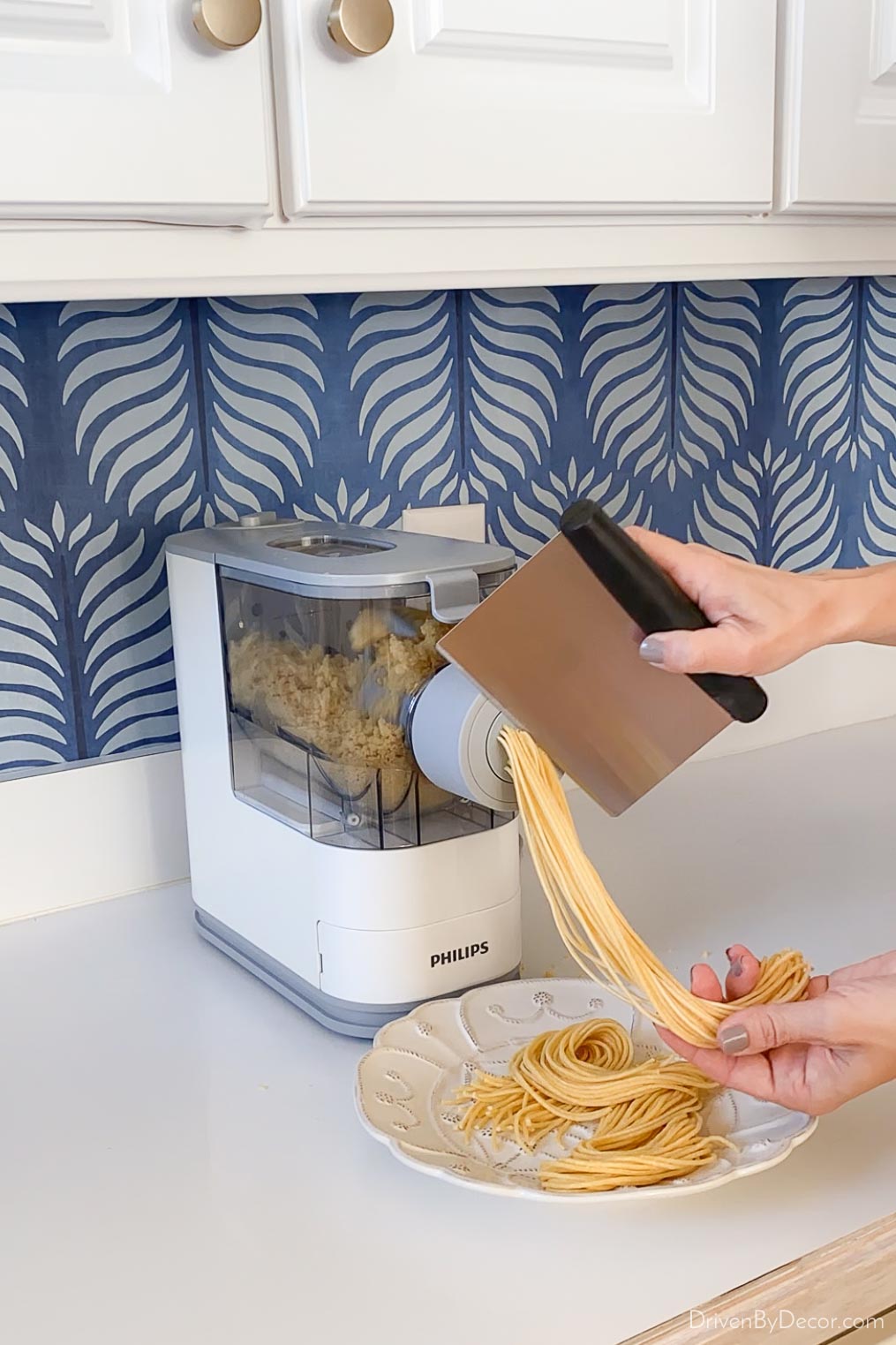 Cutting off the pasta as it comes out of the pasta making machine