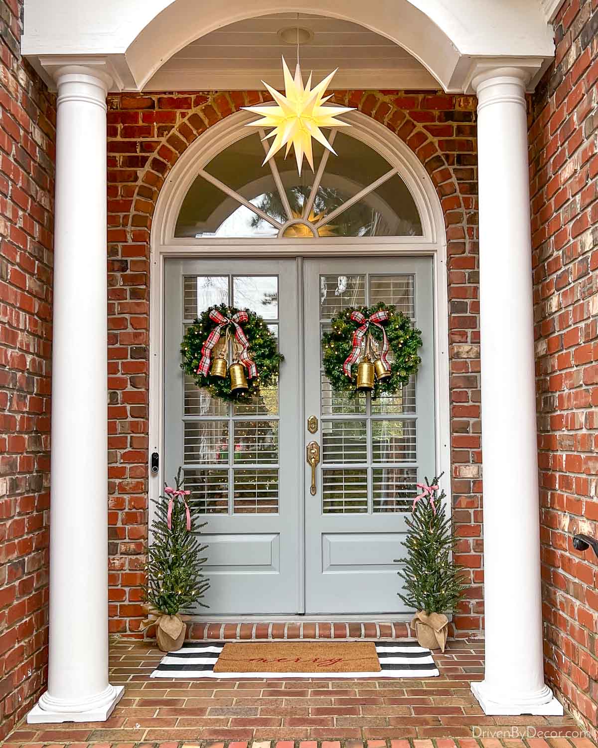 Front porch with Christmas wreaths tied with bells and hanging star
