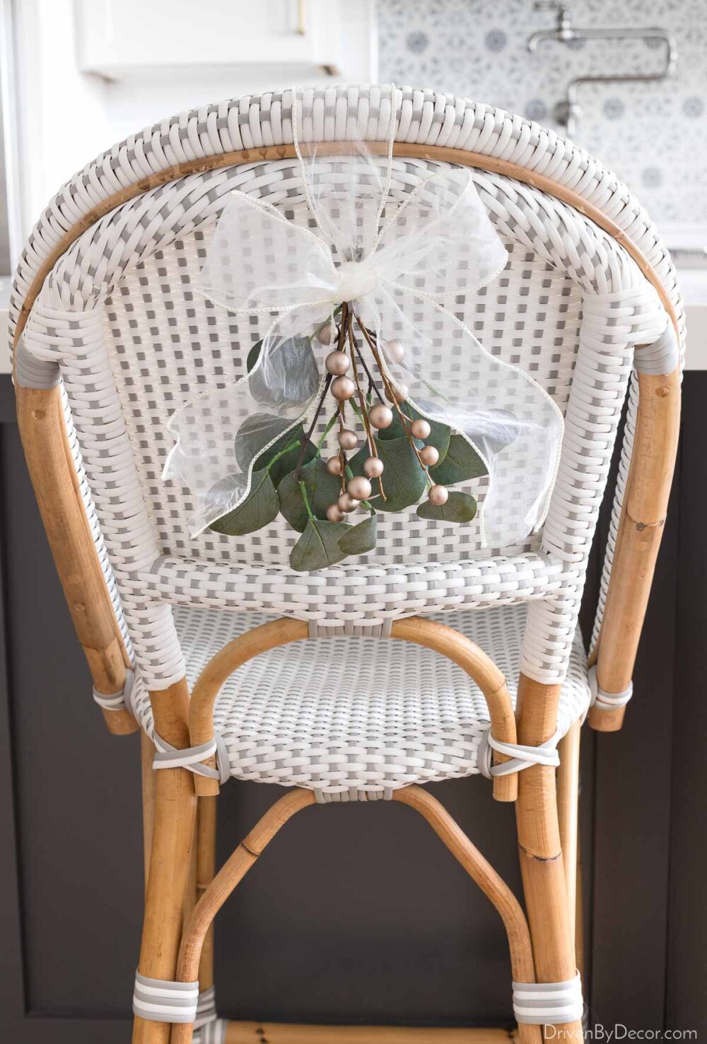 Adding a sprig of eucalyptus and gold berries to chair backs - love this simple Christmas decoration idea!