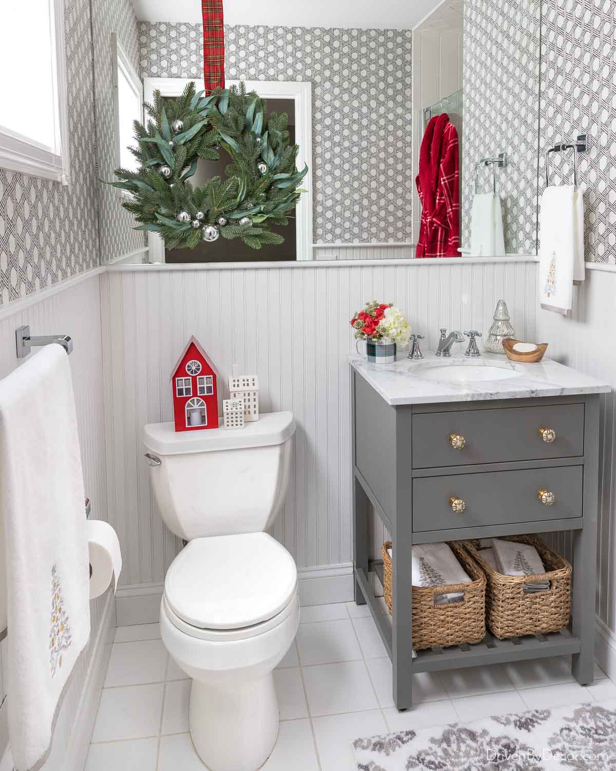 Love the look of a wreath hung on the mirror in this cute guest bathroom!