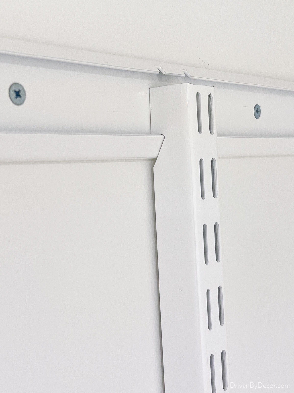 Vertical rails of the Elfa closet system hooked on the top rail