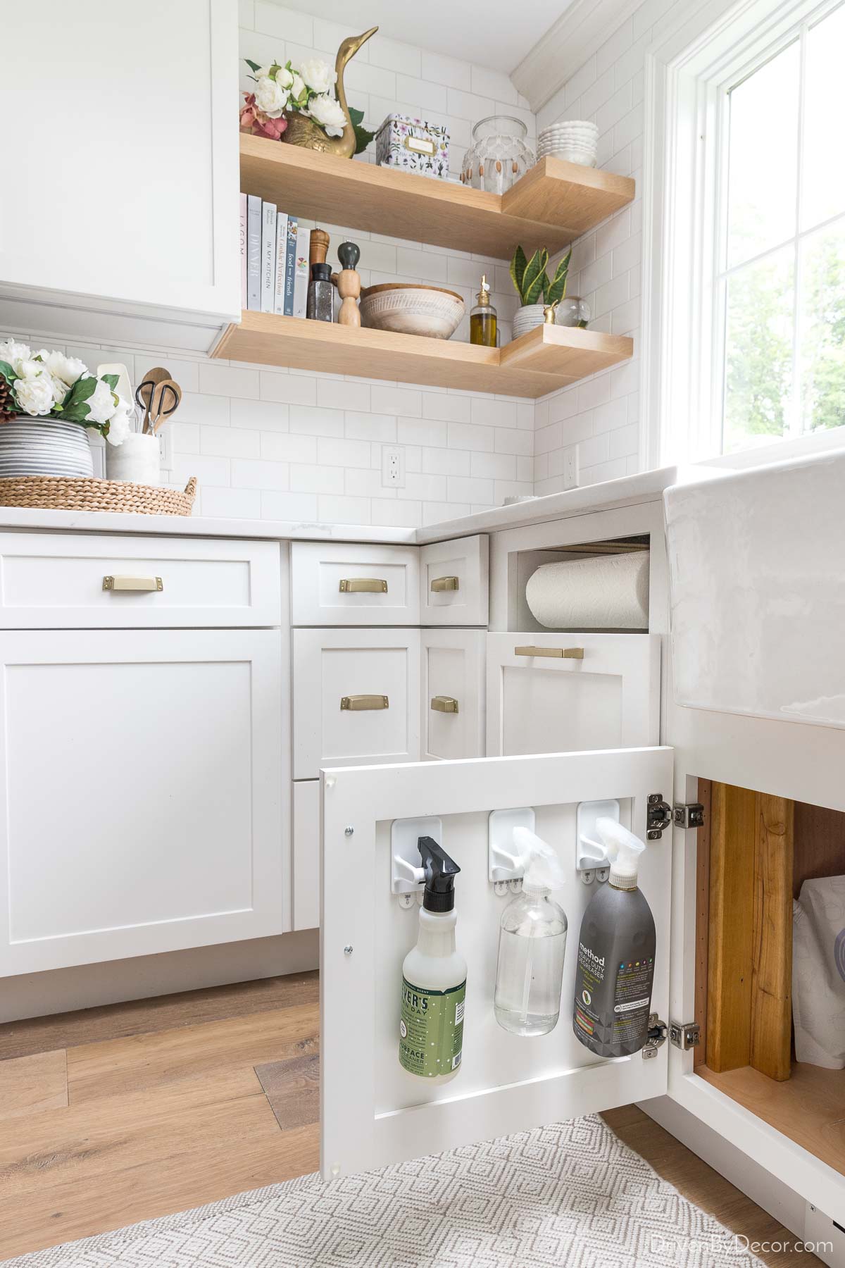 Organized kitchen with spray bottles on hangers on back of cabinet door