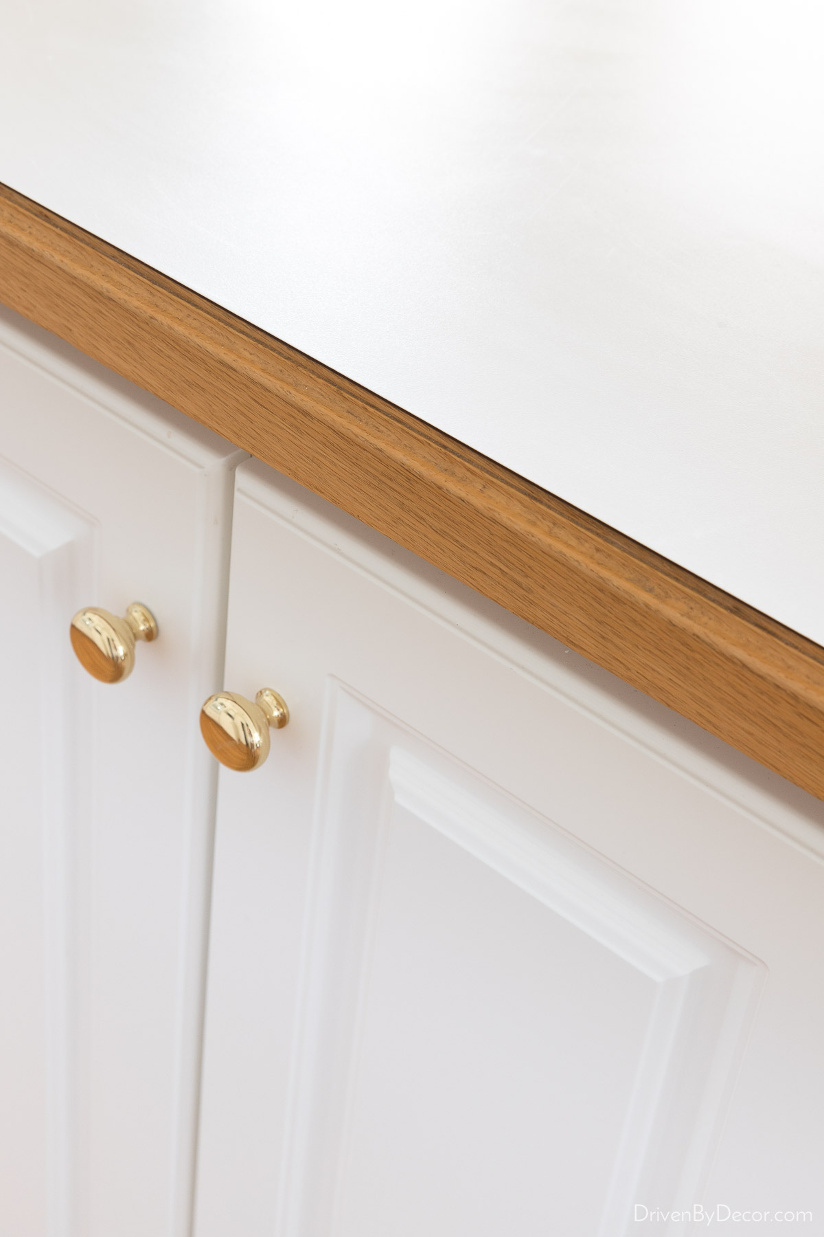 The dated hardware on our kitchen cabinet that was replaced as part of our budget kitchen remodel