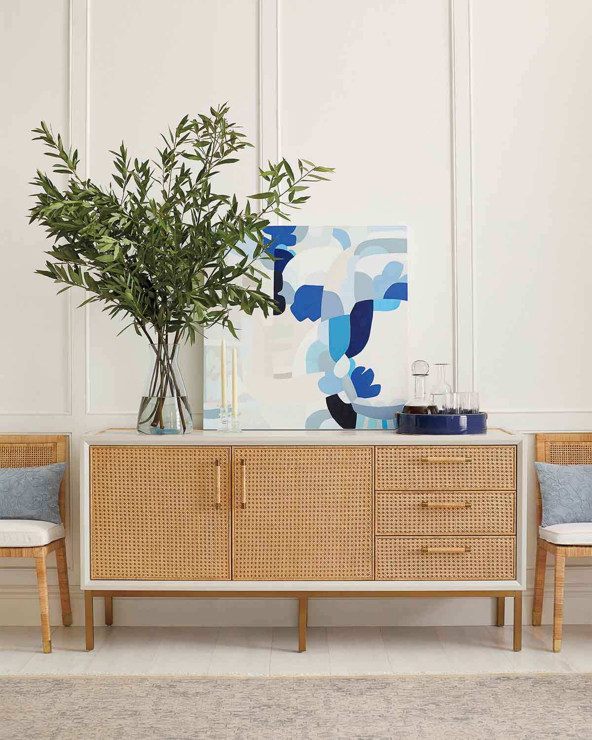 Sideboard with art and vase with greenery as dining room wall decor