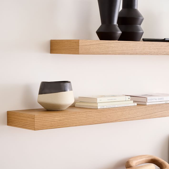 Floating oak shelves that are shallow enough to use over a toilet