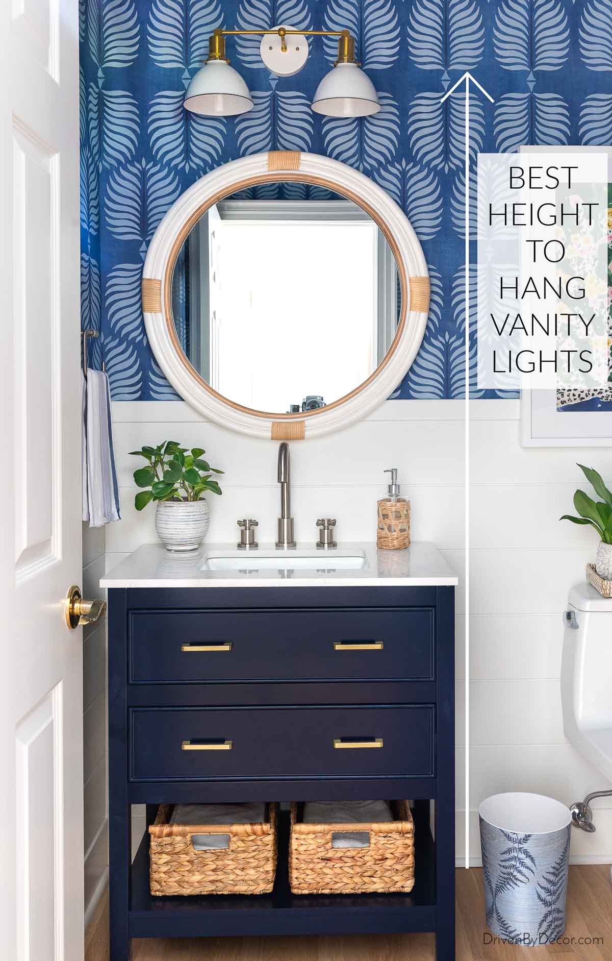 Powder room with vanity lights over round mirror showing how high to hang vanity lights
