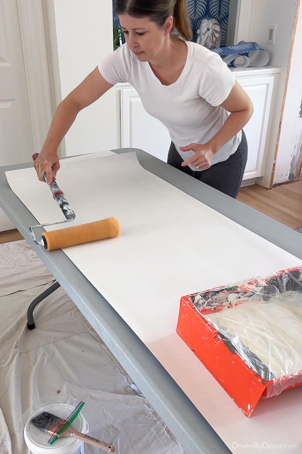 Rolling on paste to the back of wallpaper