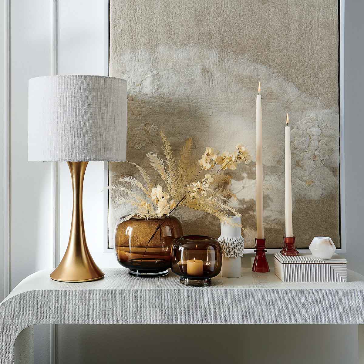 Lamp, candlesticks, art, and other console table decor