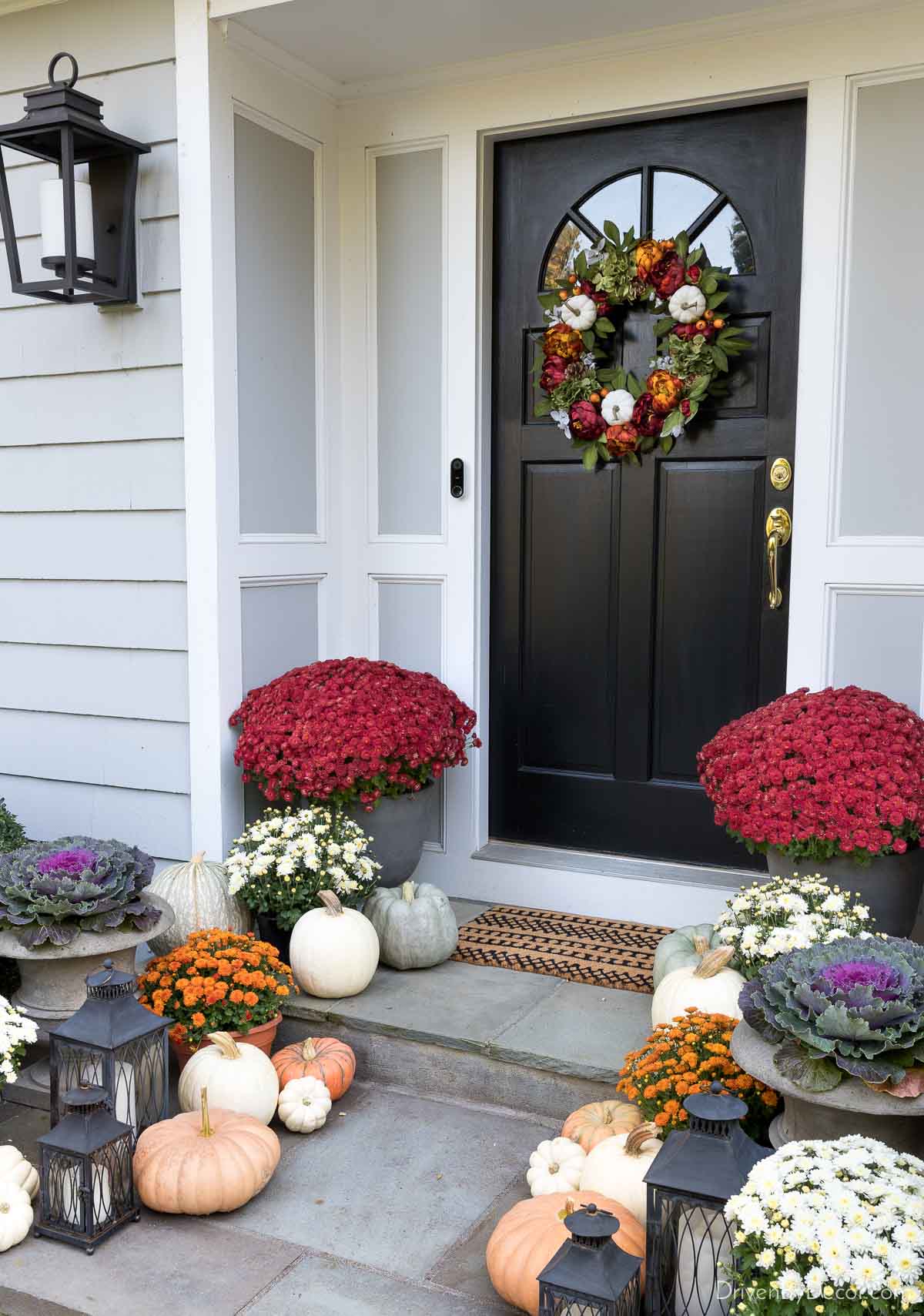 Fall porch decor - mix of lanterns, mums, pumpkins, & cabbages