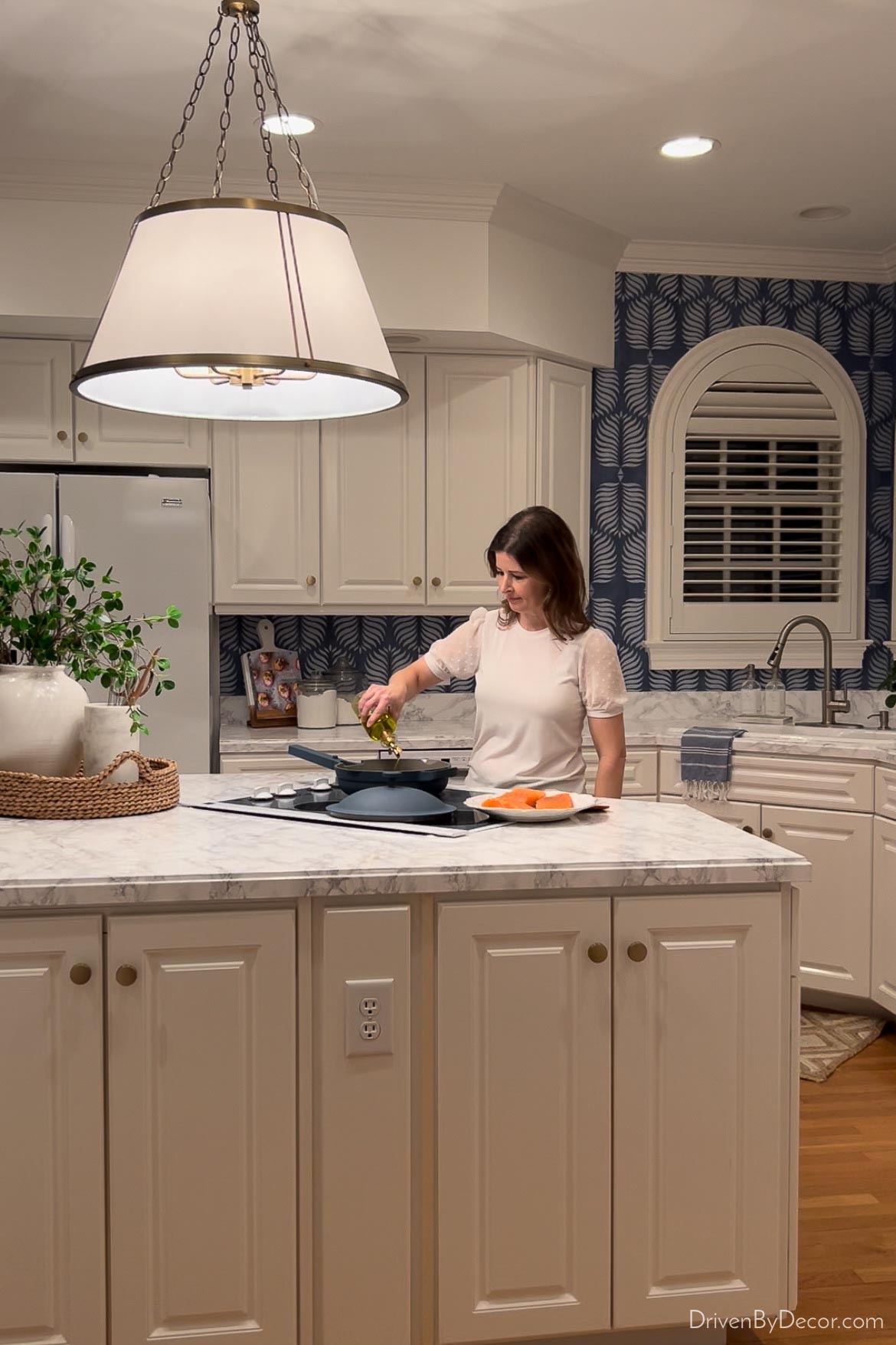 Cooking on kitchen island range with lit pendant light above