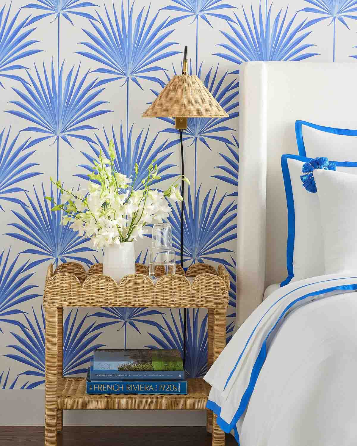 Scalloped rattan side table used as nightstand