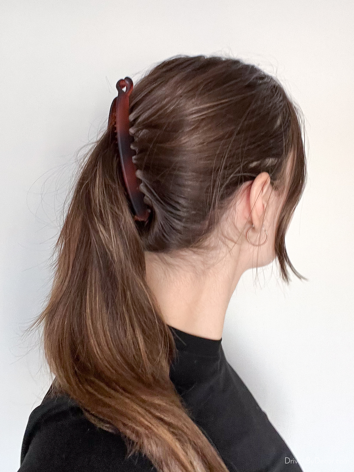 Banana clip clipping hair back into a pony tail