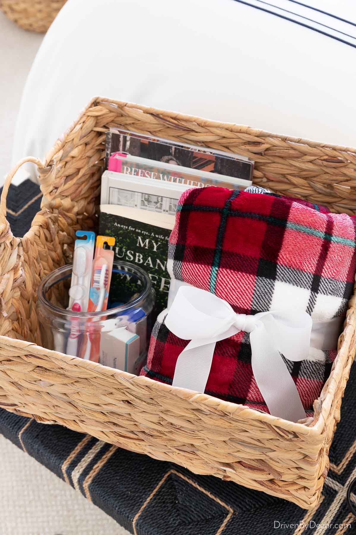 Basket with books, toiletries, and throw blanket for guests