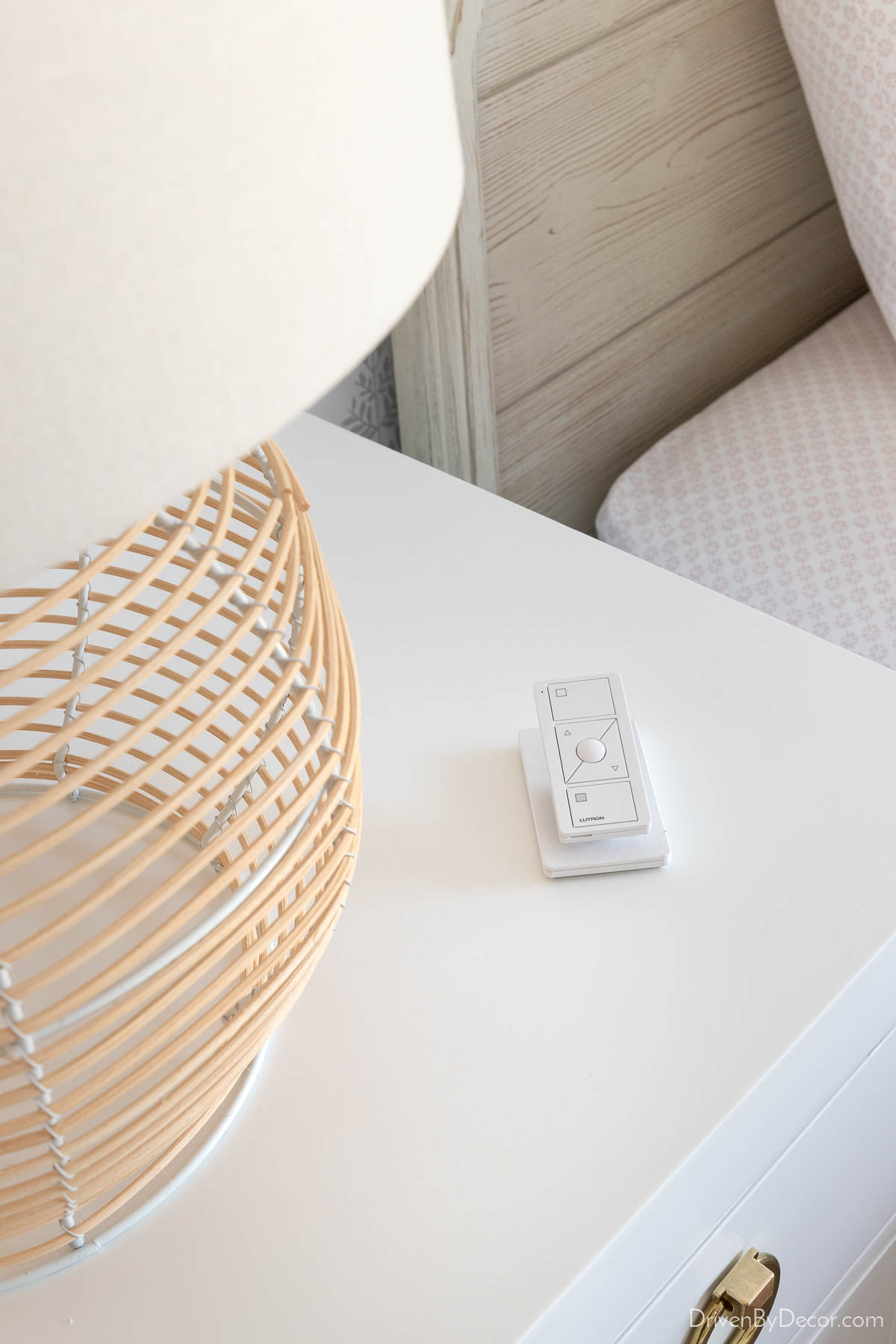 The Pico Smart Remote next to a lamp on a nightstand