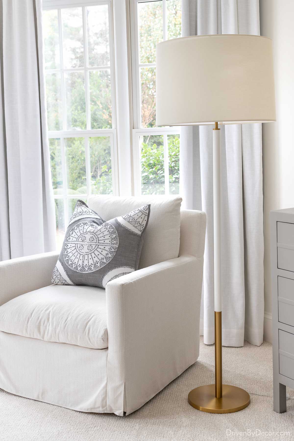 Brass & white bedroom lamp next to reading chair