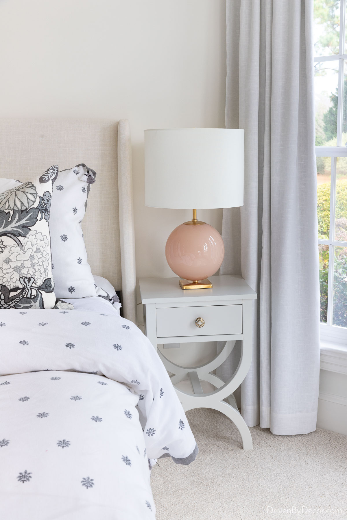 Blush bedroom lamp on nightstand next to bed