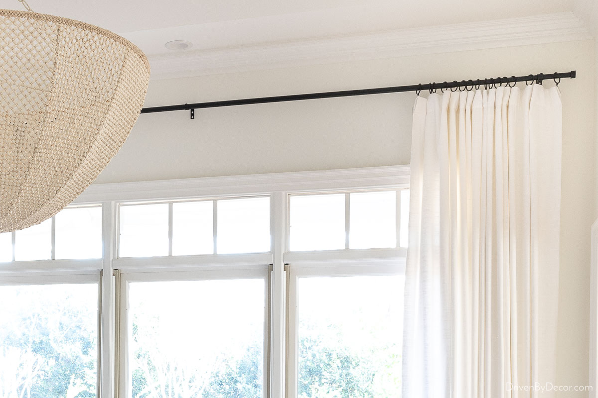 A great inexpensive black curtain rod holding white curtains