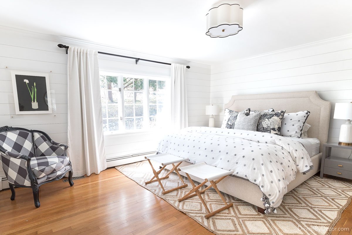 Bedroom with large window with white curtains 