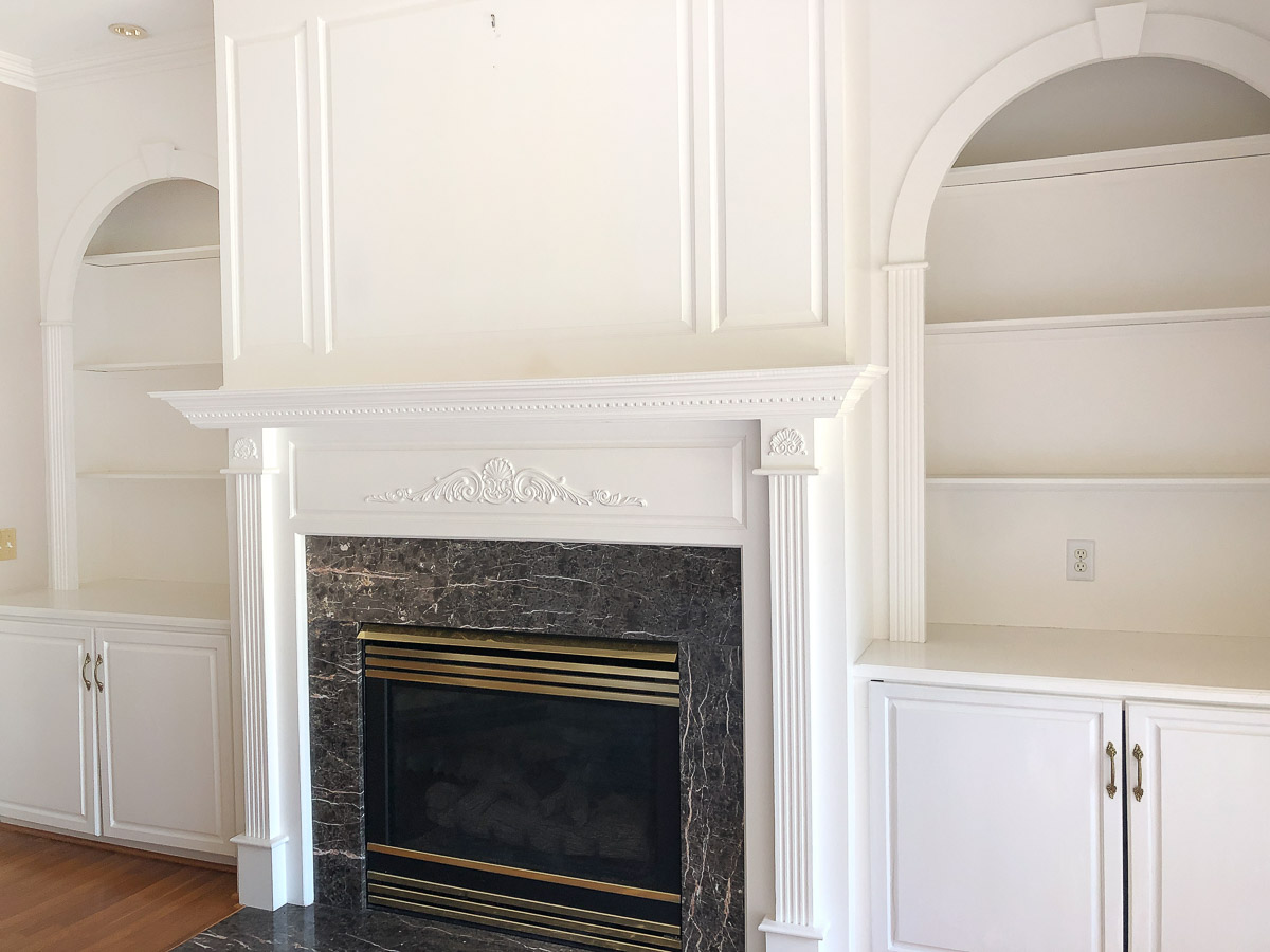 Living room fireplace with bookcases on each side before renovation