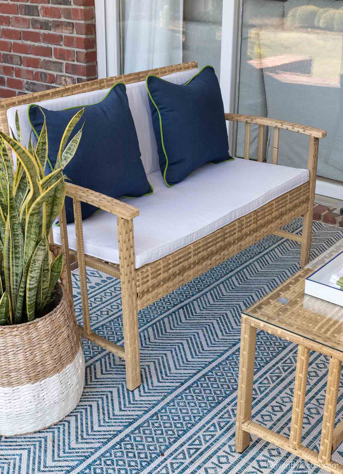 Pair of navy Sunbrella outdoor pillows on our woven loveseat