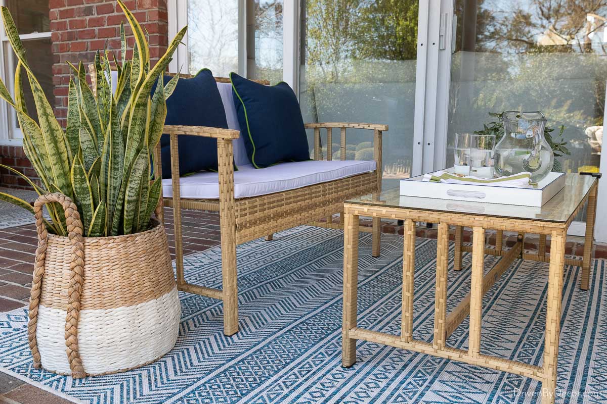 Woven outdoor loveseat and coffee table on back porch