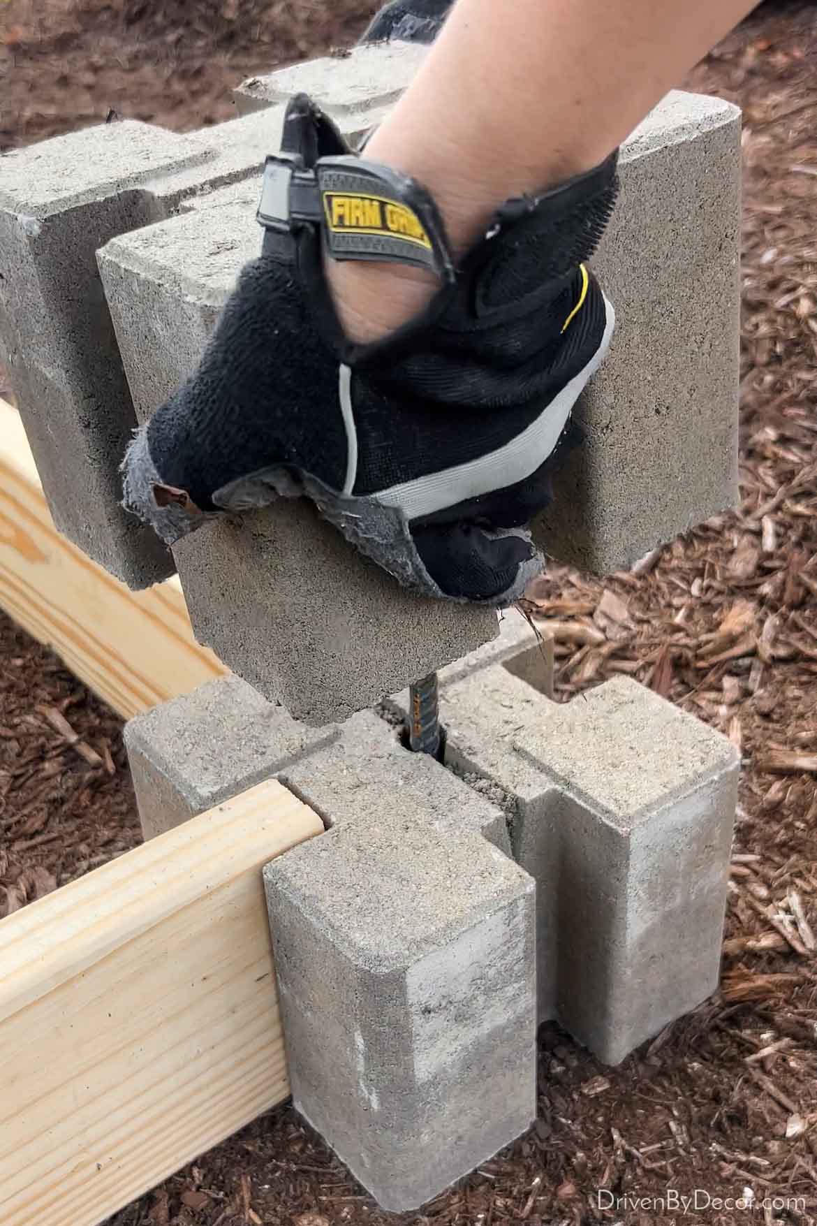 Stacking one corner block on the other to create a raised garden bed