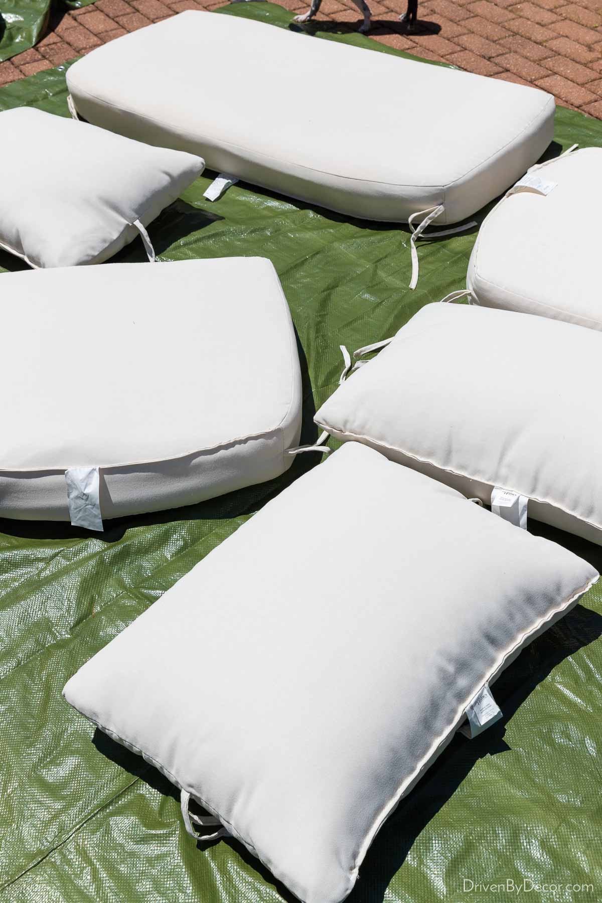 Outdoor cushions drying in the sun on a tarp after being cleaned