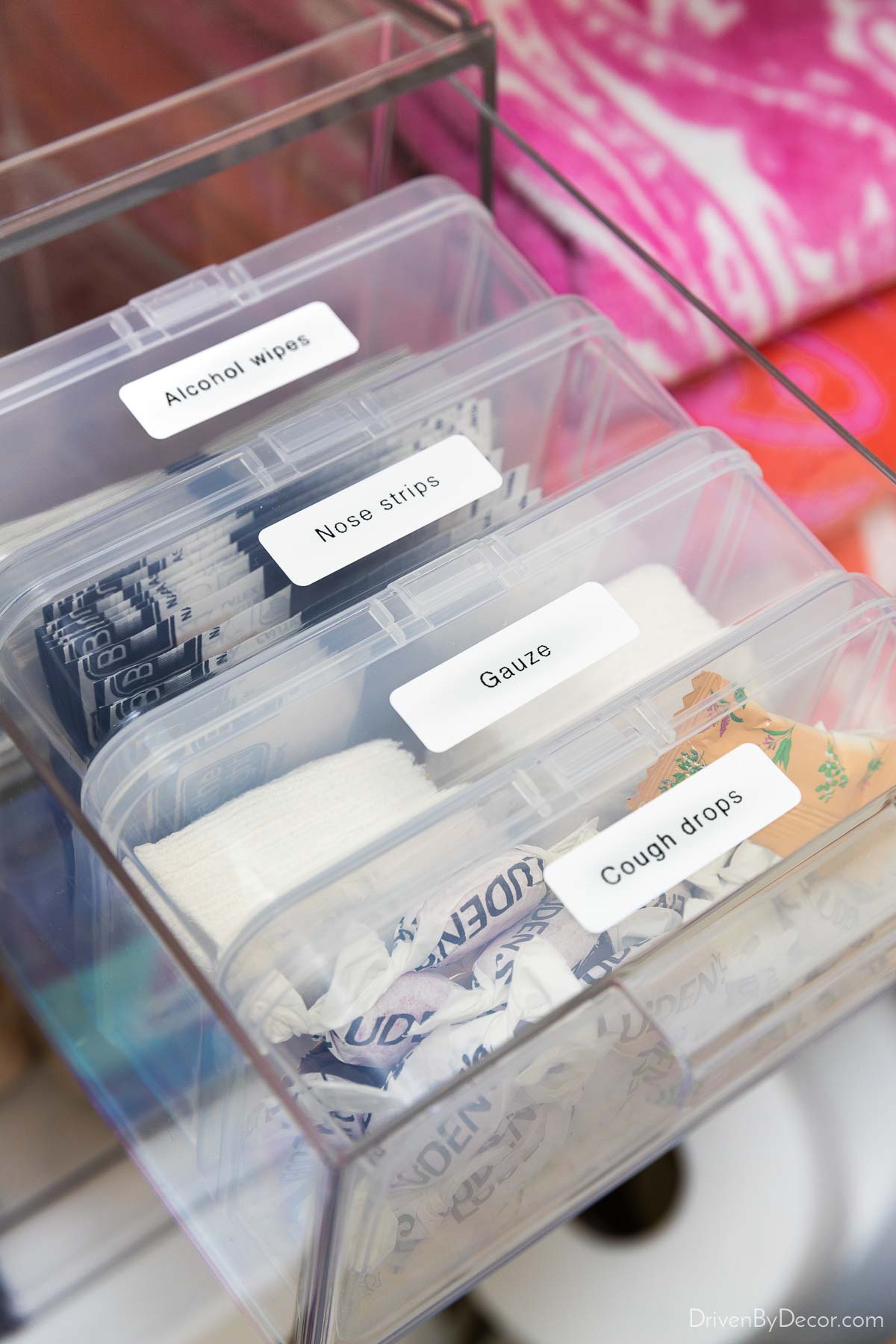 Small hinged plastic containers in acrylic drawer in linen closet