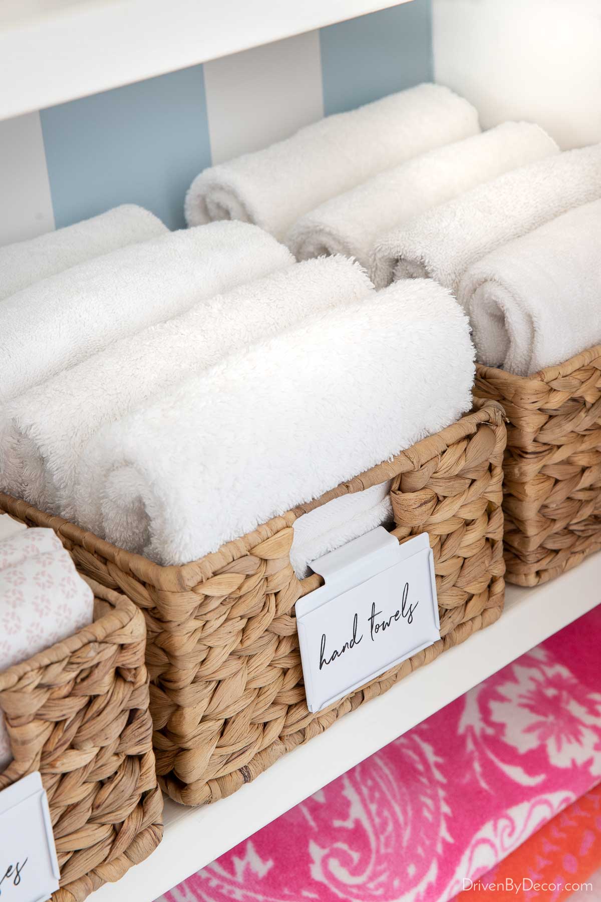 Folded hand towels in basket in linen closet