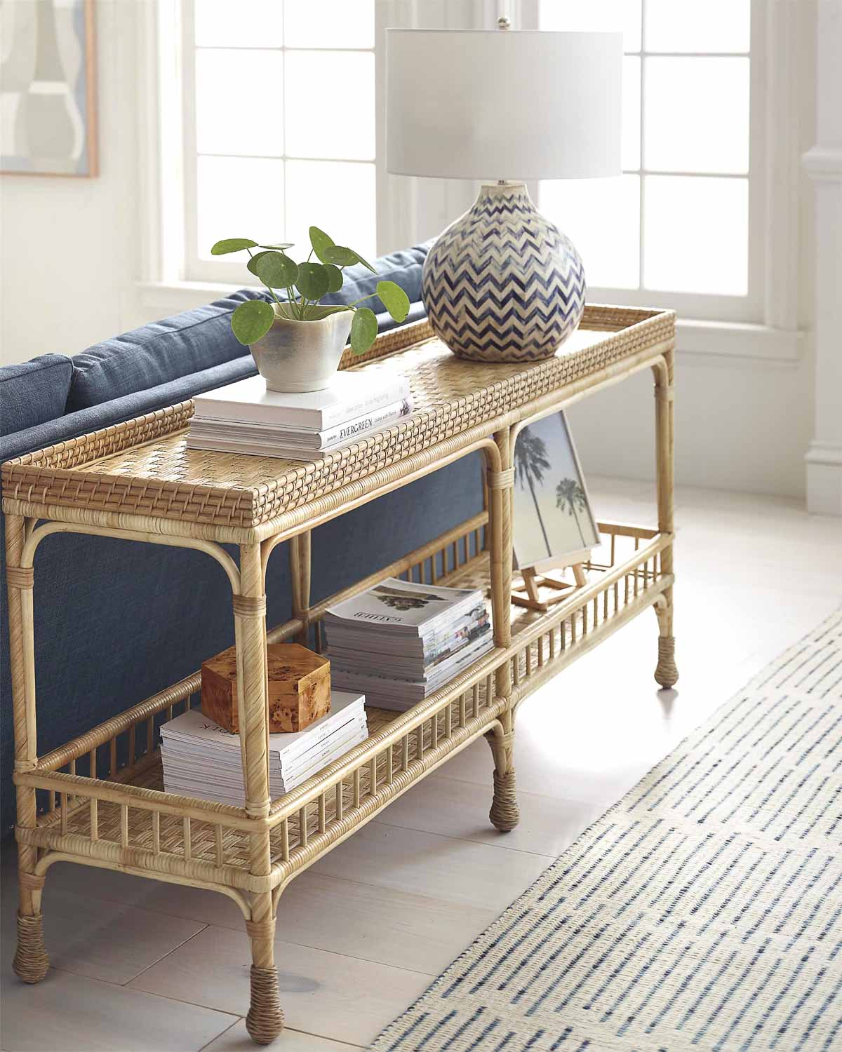 Rattan sofa table decorated with lamp and accessories behind living room sofa