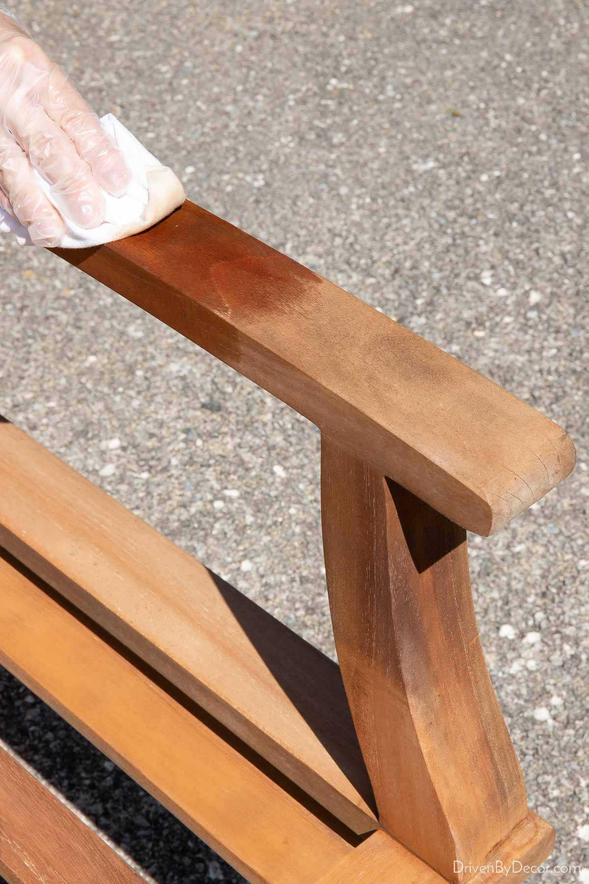 Applying teak conditioner to chair arm showing how the conditioner darkens the color