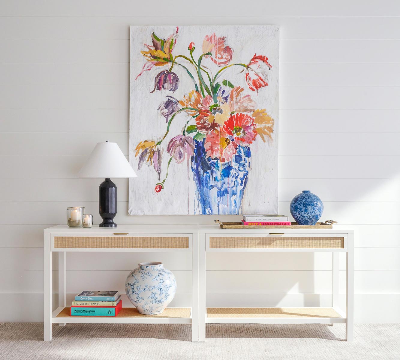 Two cane console tables placed side by side to create one long sofa table