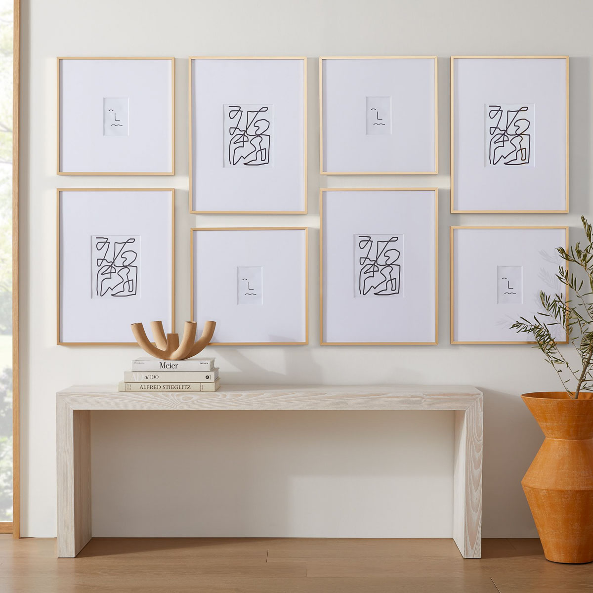 Gallery wall layout in a modern grid above a console