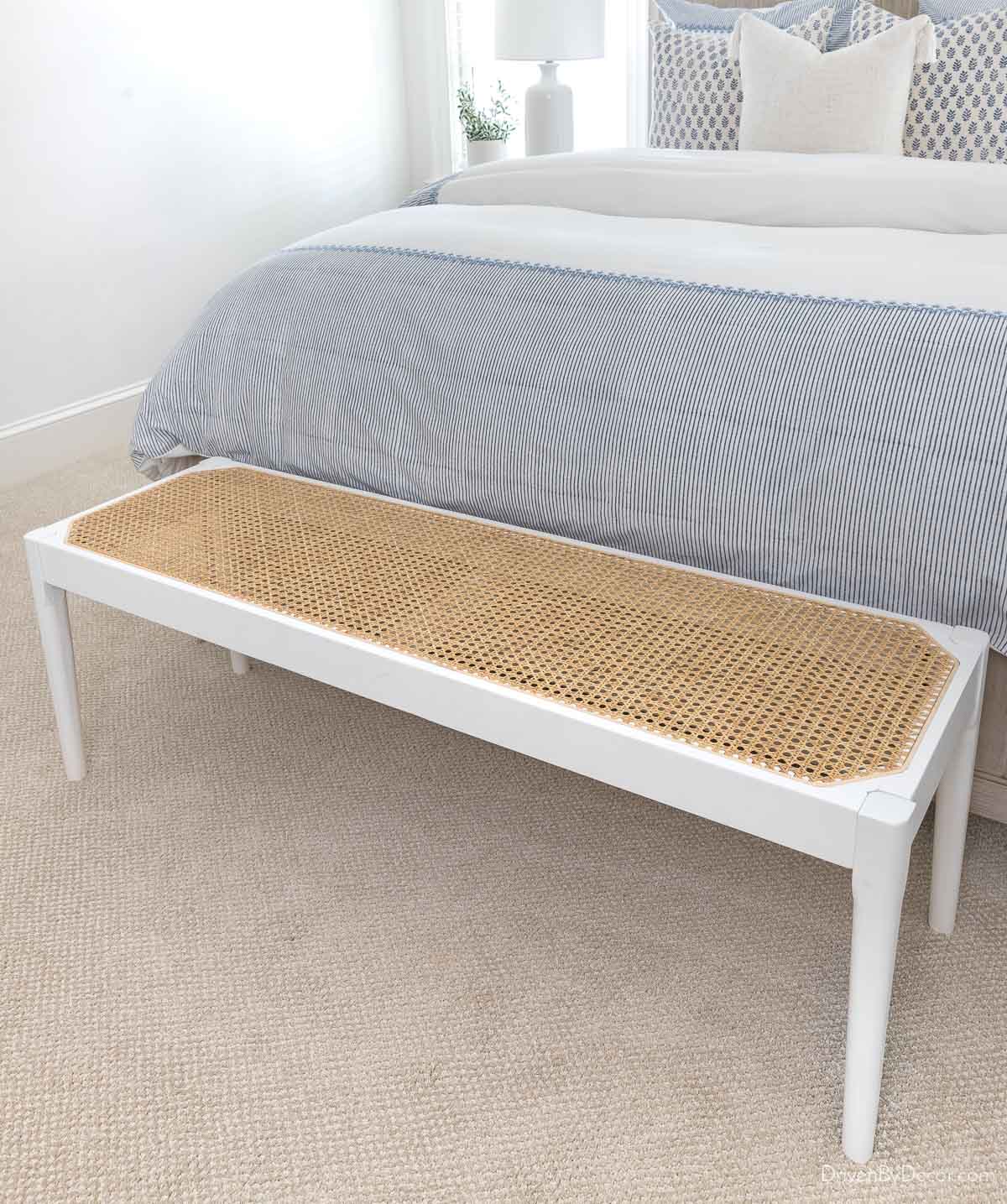 Cane bench at end of bed as a coastal bedroom decor idea