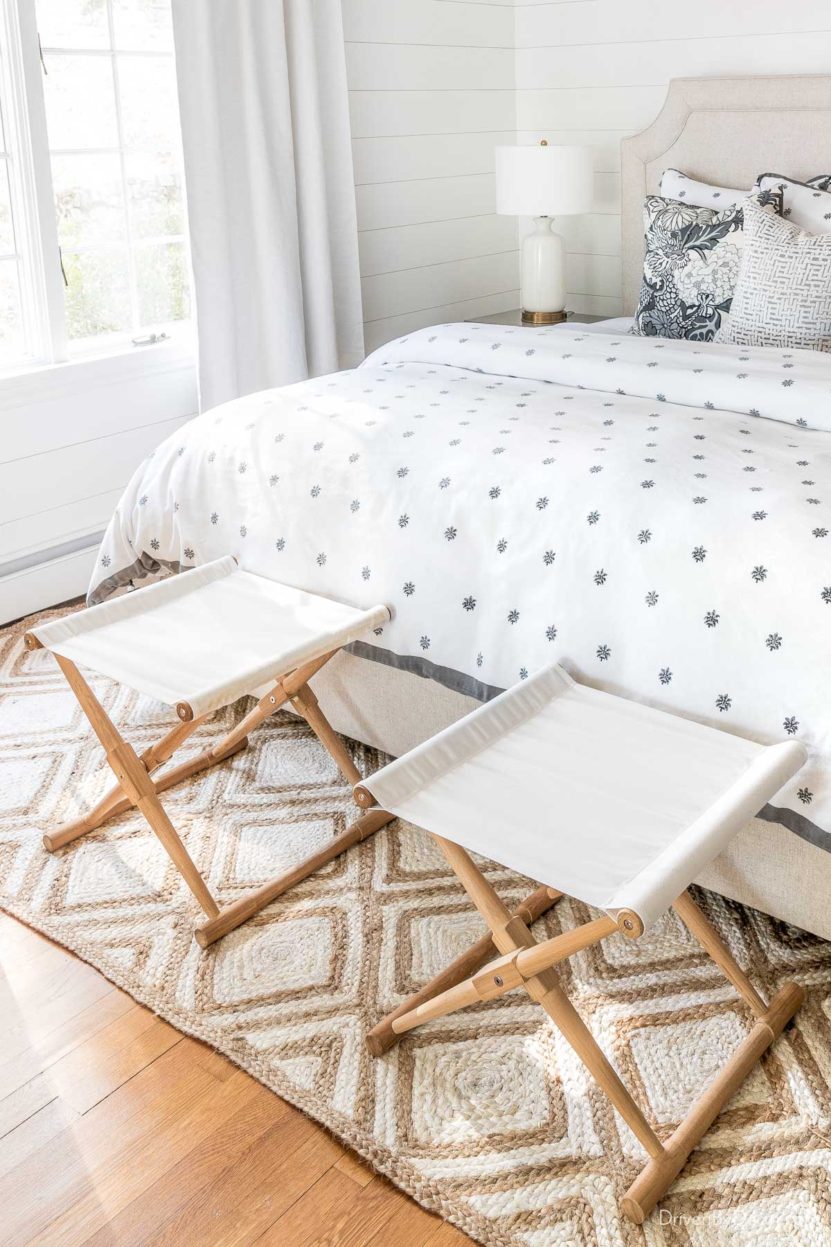 Pair of camp stools at the end of bed to hold clothes for the next day