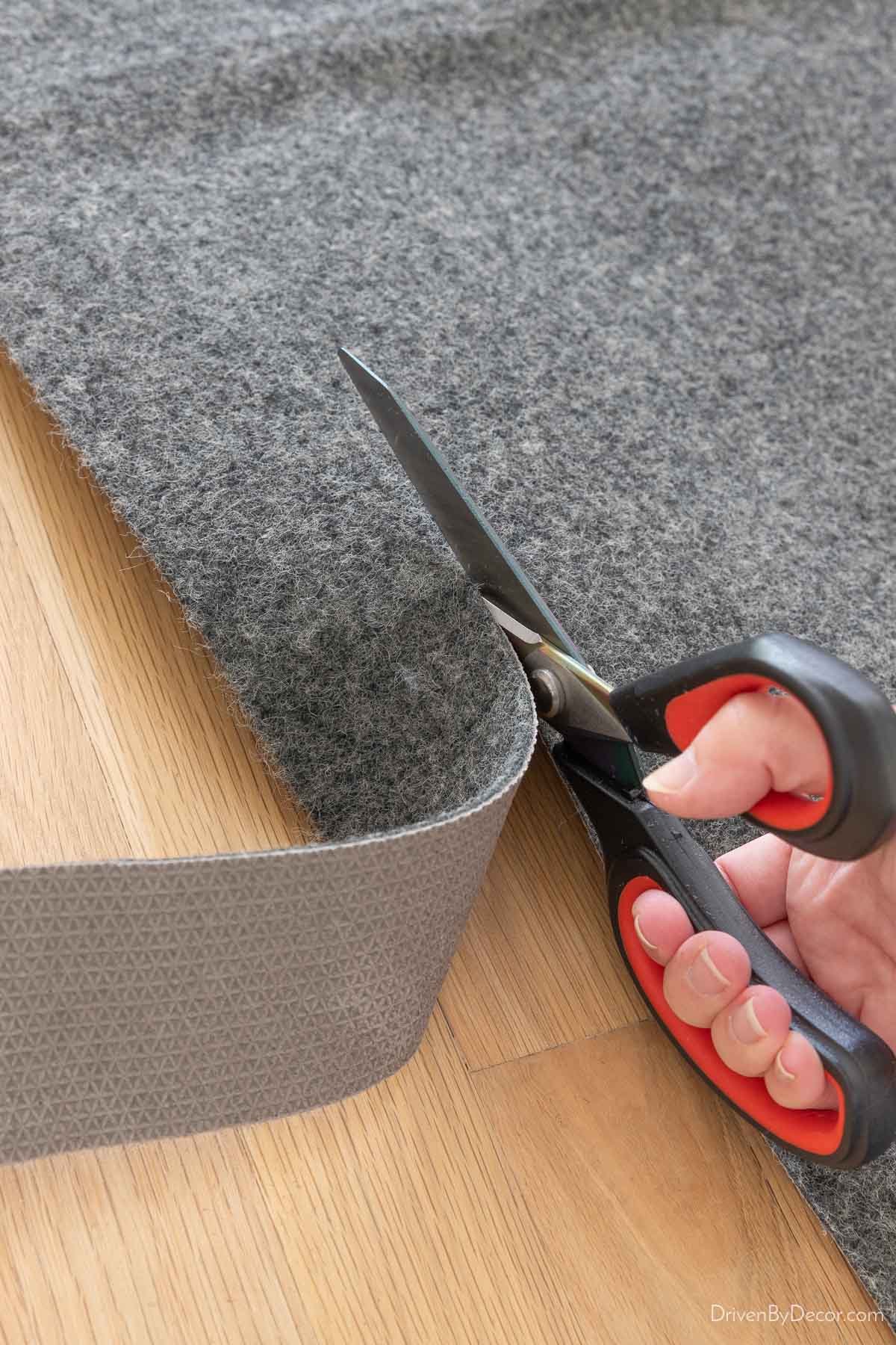 Cutting a rug pad with scissors