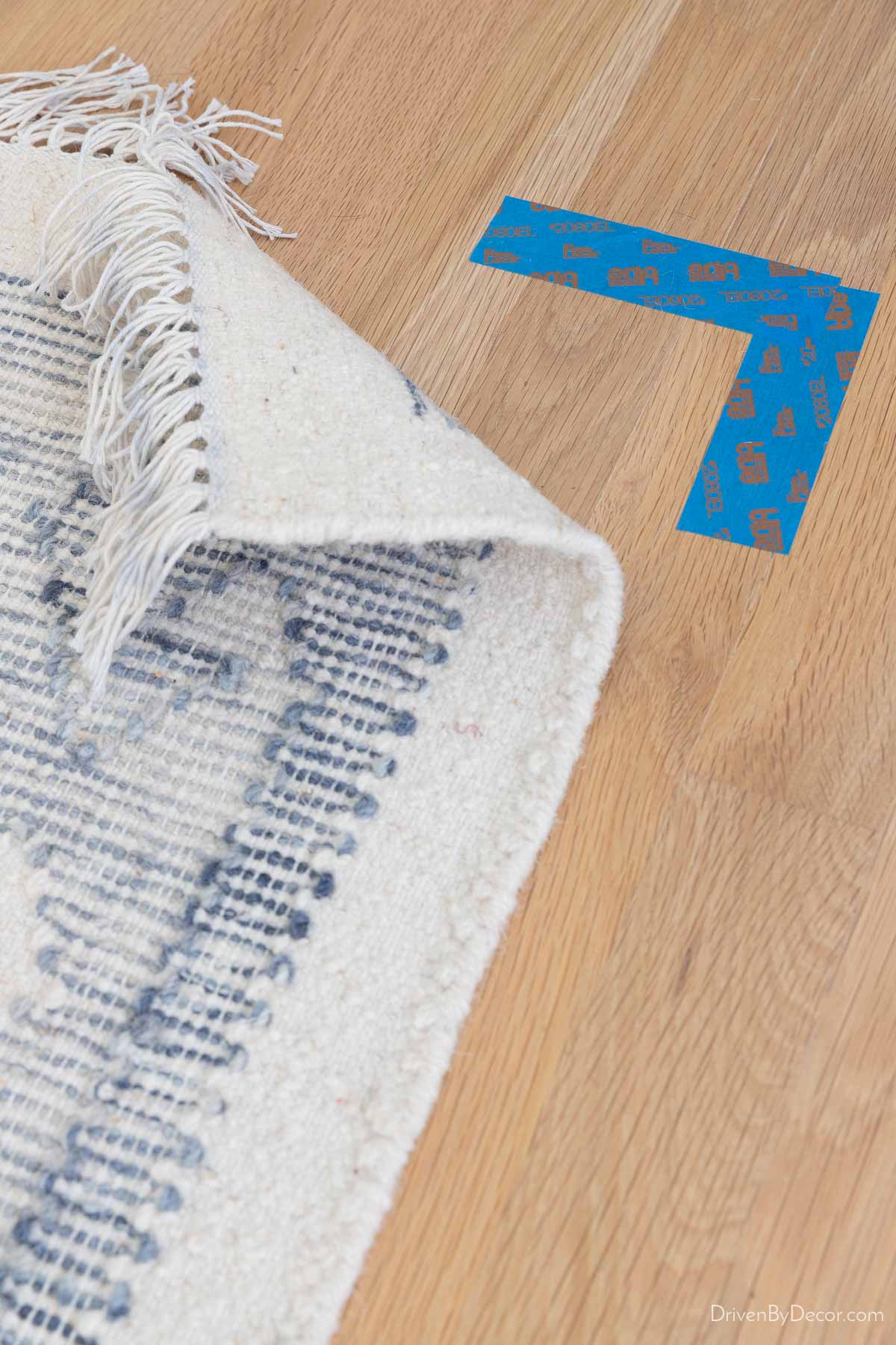 Corner of rug marked with tape on hardwood floor