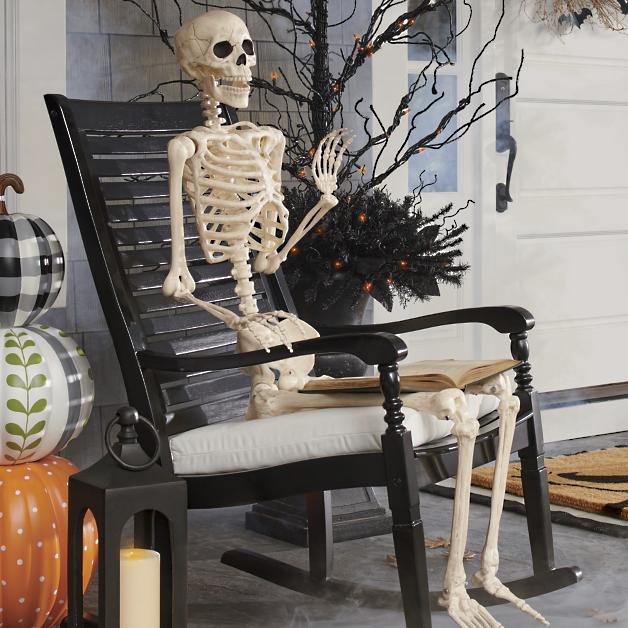 Skeleton sitting in rocking chair on front porch for Halloween