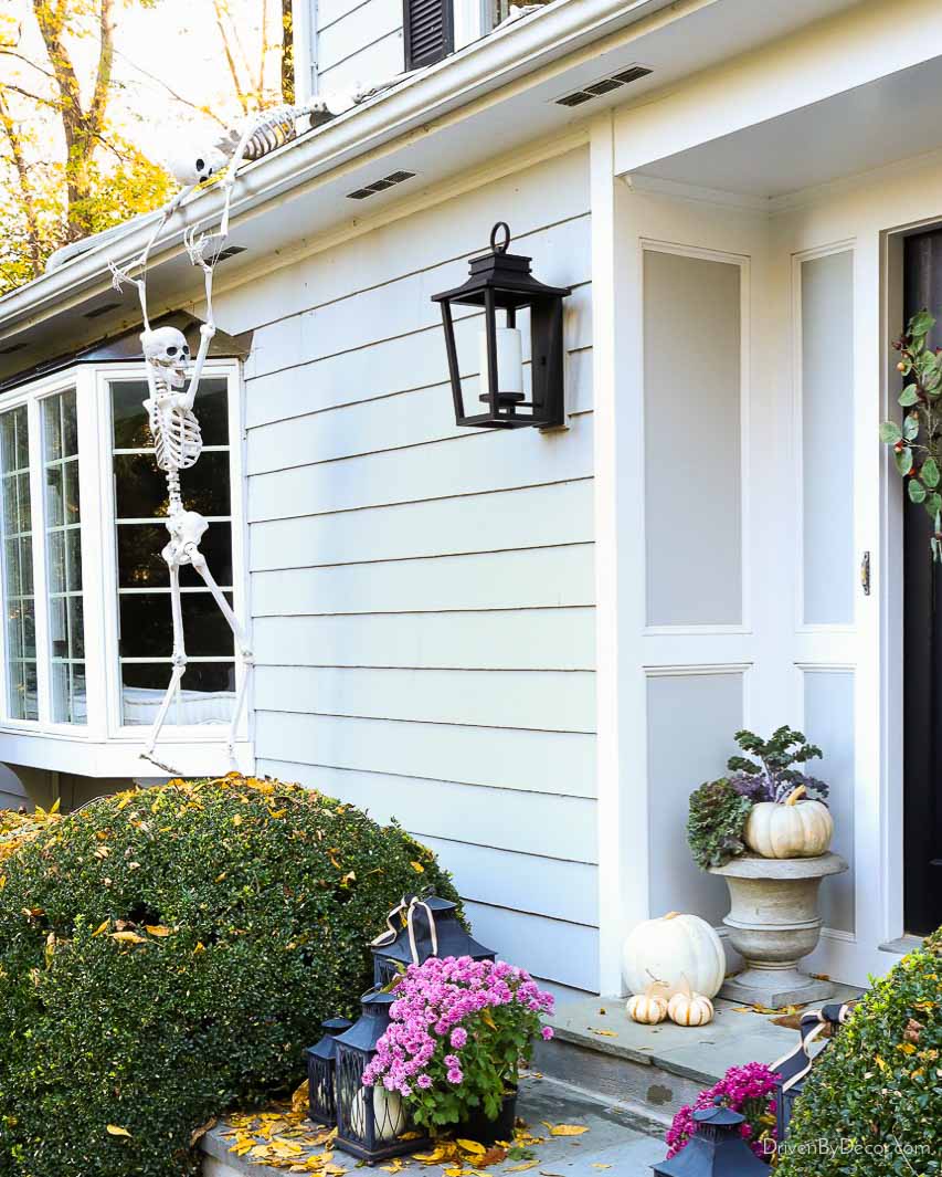 Skeletons climbing up house as Halloween porch decor