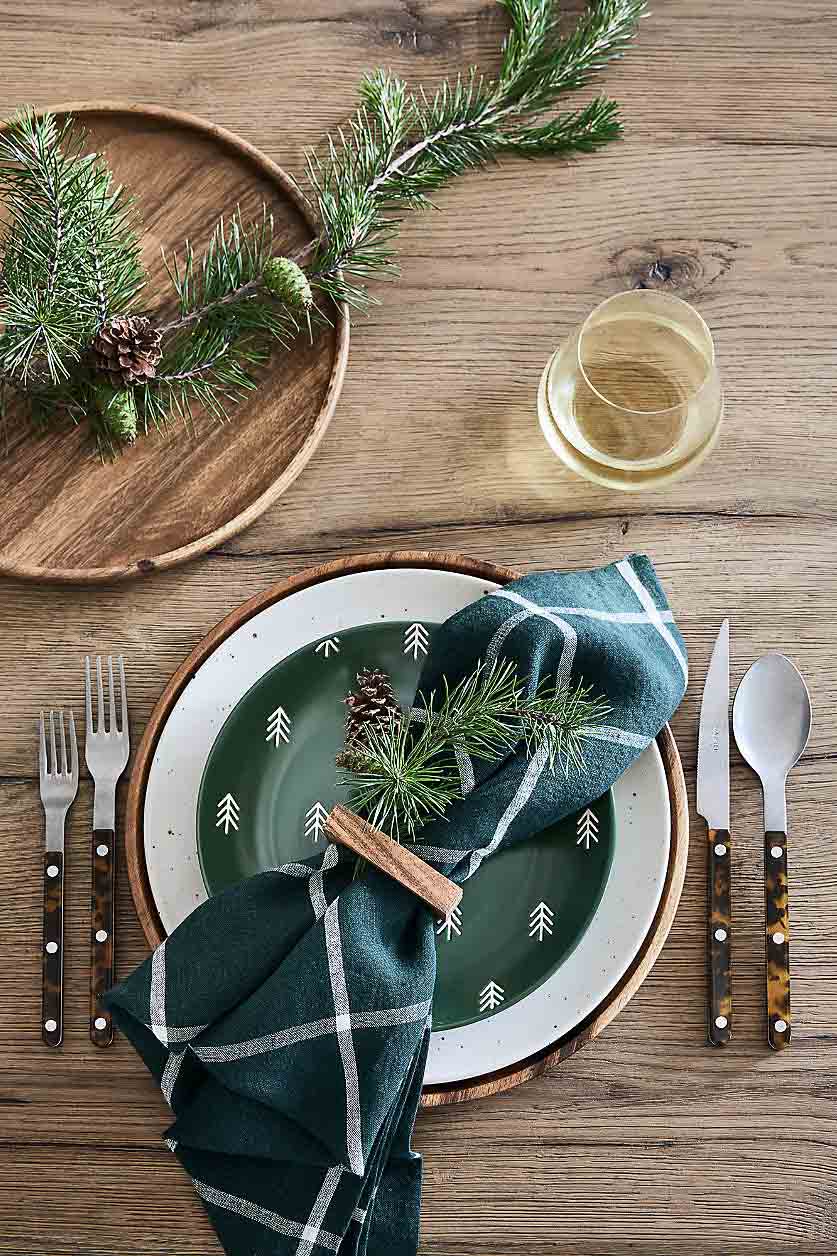 Christmas table decor with greenery tucked in napkin rings