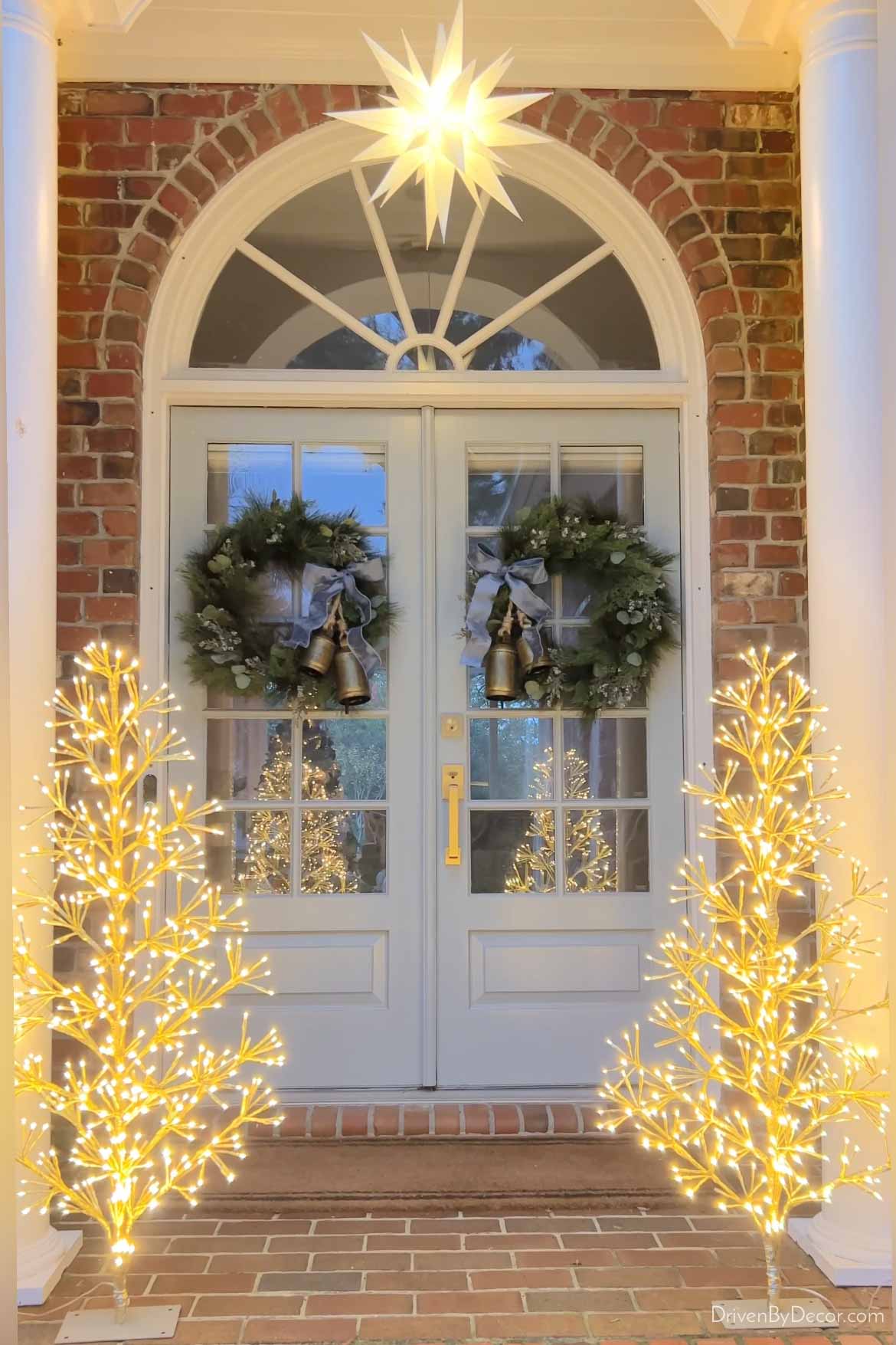 Pair of twinkling LED trees on front porch at Christmas