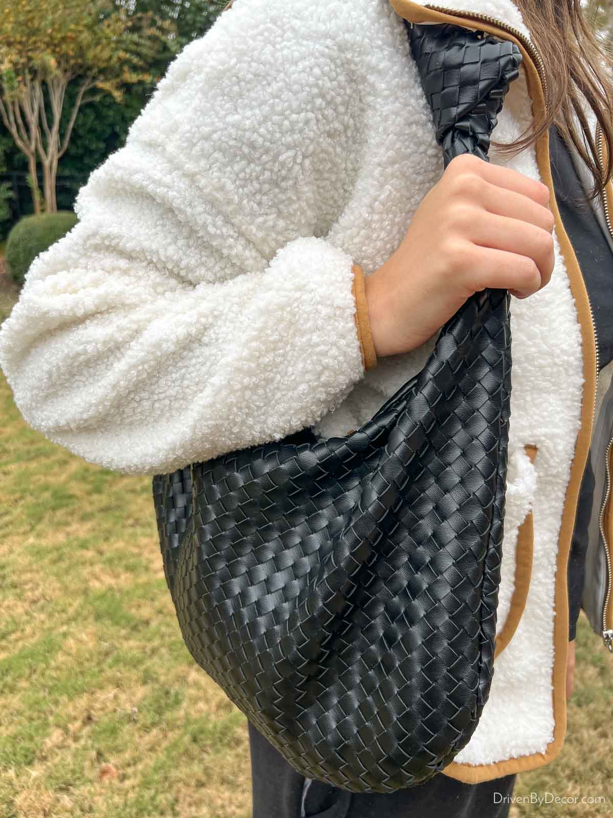 Black woven handbag carried on shoulder