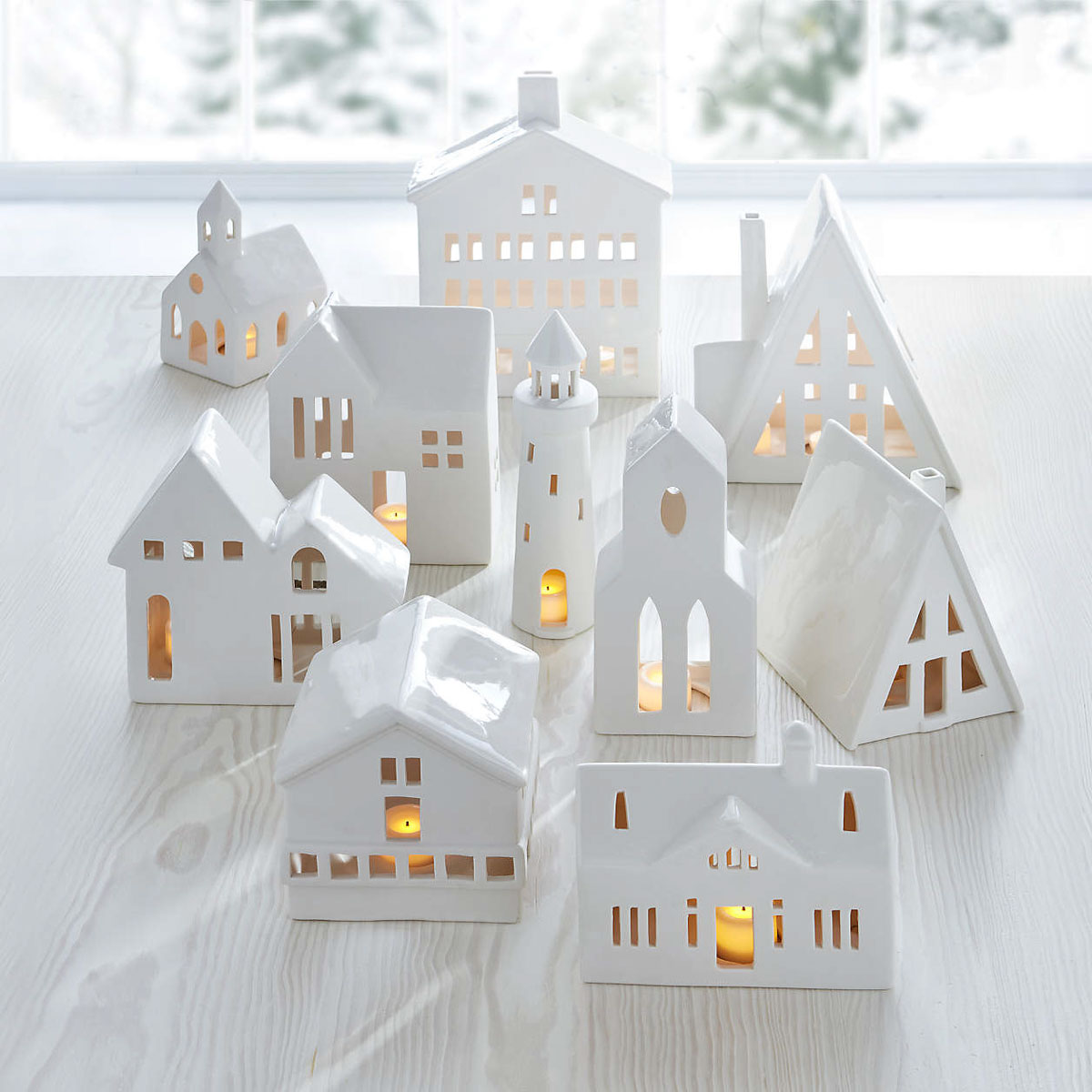 10 Christmas Table Decor Ideas to Steal! White ceramic houses lit with tea lights