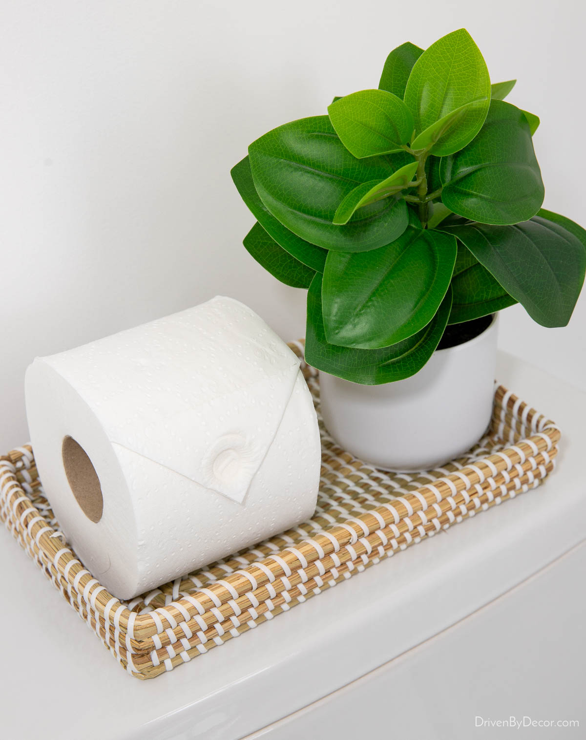 Woven toilet tray and small plant as a toilet tank decor idea