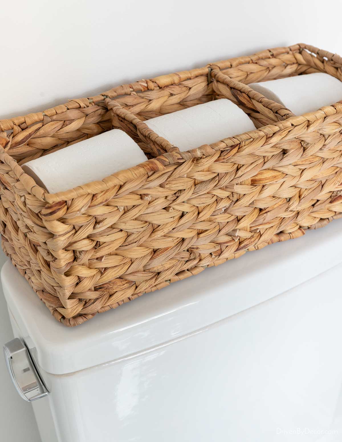 Woven toilet paper holder on toilet tank