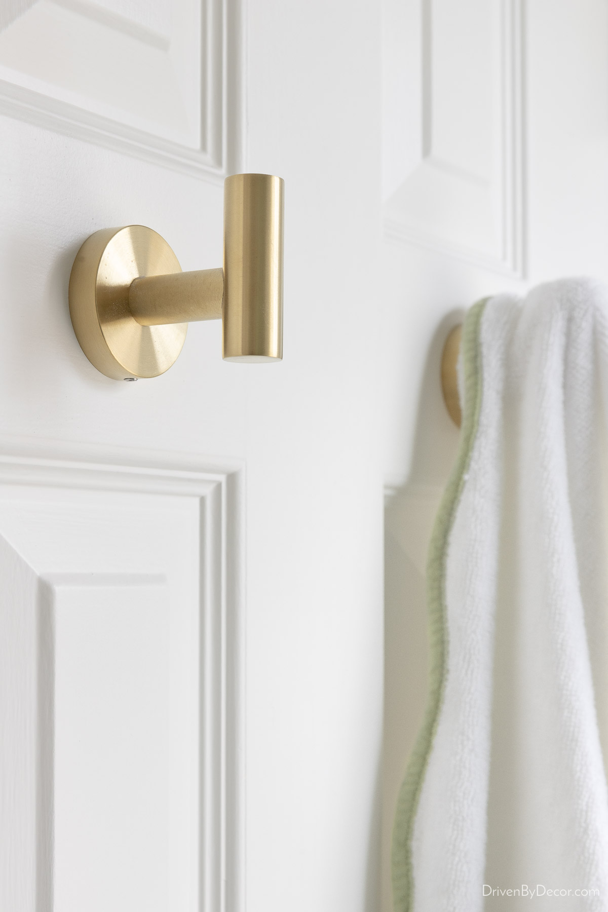 Simple brass towel hooks on back of door