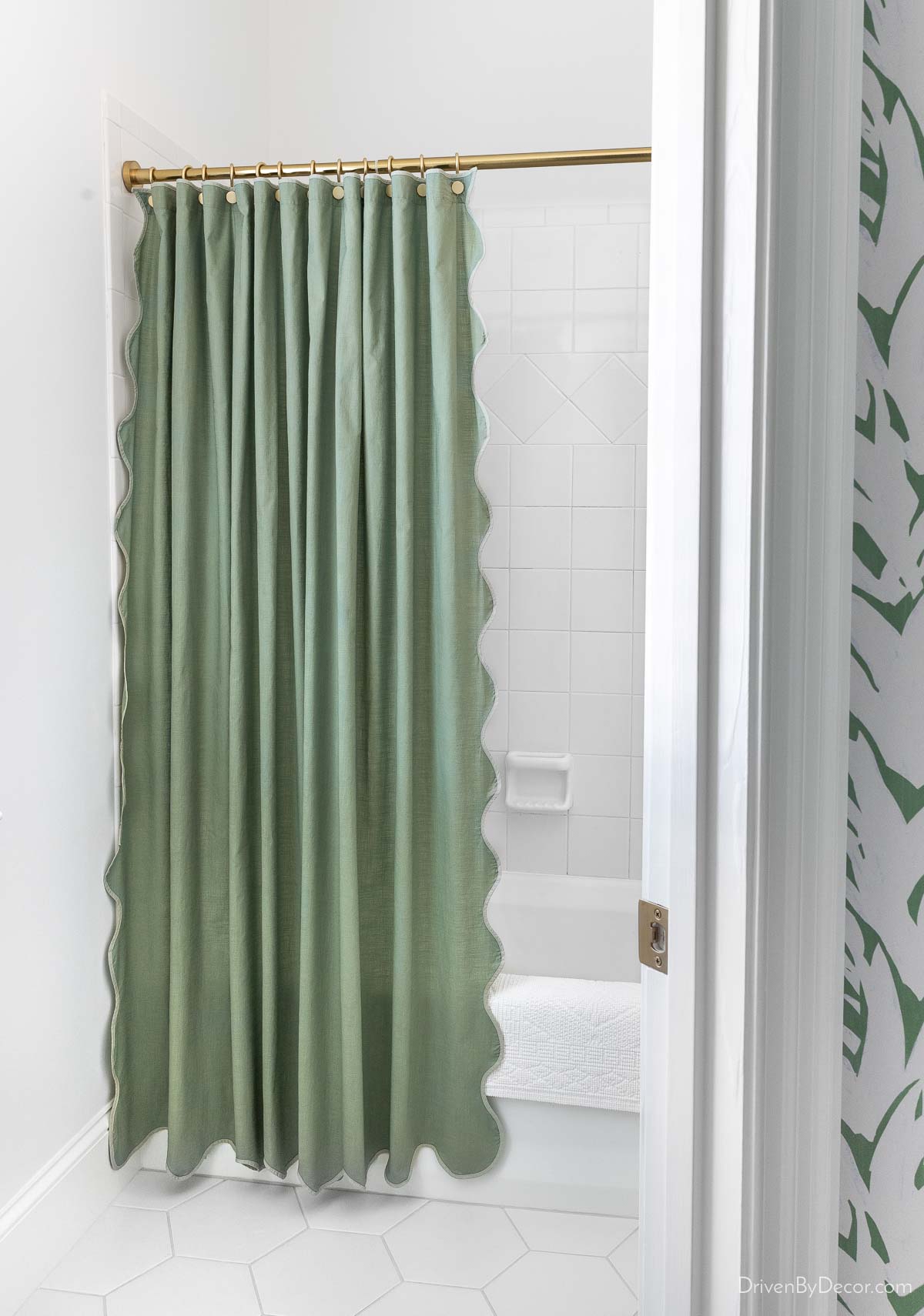 Scalloped green shower curtain with brass rod